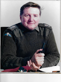 Colour photo of Lt Col Pat Conn at his desk.