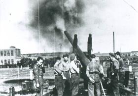 Seven men of 64 Medium Regiment RA fire from the power station at Nijmegen with a 5.5 inch gun.
