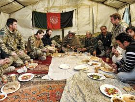 Officers from 3 PARA along with key members of the local community attend a post shura lunch, Afghanistan, 2011