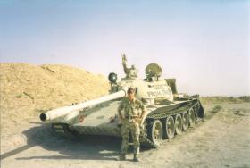Soldier from 4 PARA poses with an abandoned tank in the desert, Iraq, c.2004