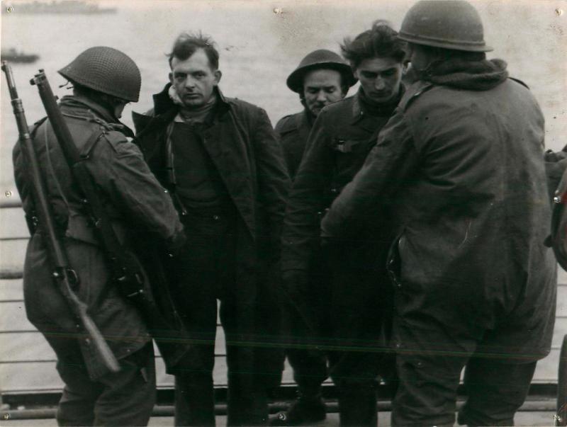 Troops search a German prisoner captured at Bruneval.