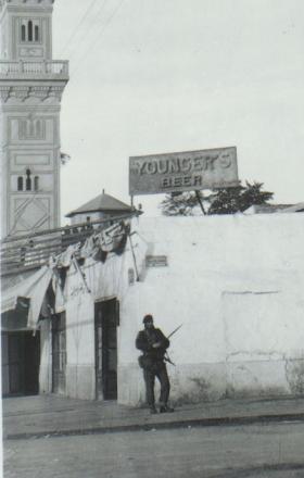  Cpl Smith, 3 Para, patrols under familiar beer sign, Ismailia, Egypt