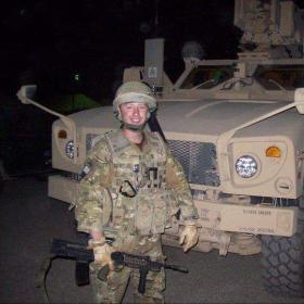MJ Flynn standing in front of armoured vehicle