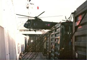 Shipping containers and a helicopter on the deck of the Canberra