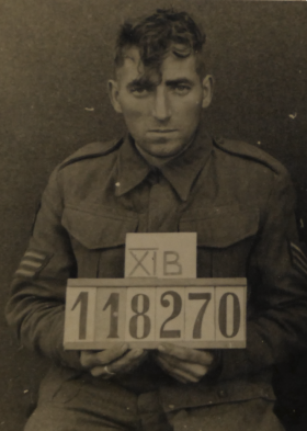 A black and white image of Sgt Smith holding a PoW ID plate