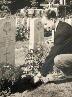 Harold Back laying flowers at the grave of Ted Orbell