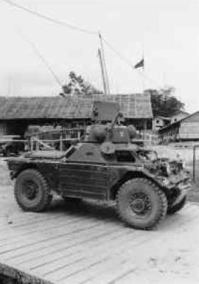 OS Armoured Car with Support Coy HQ in background with VHF antenna above flag