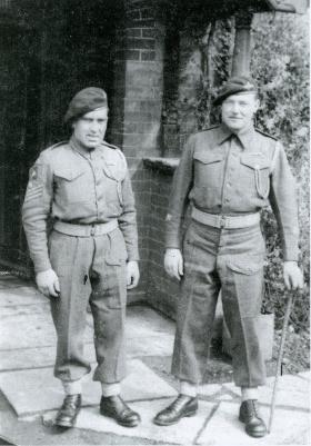 A black and white image of CSM Sharp and CSM Scott in uniform standing by a doorway.