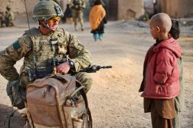 A soldier from 3 PARA talks with a local child, Naqilabad Kalay, Afghanistan, 2011
