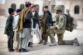 A soldier from 3 PARA talks with local children, Naqilabad Kalay, Afghanistan, 2011