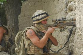 2 PARA sniper in action firing through a compound wall, Afghanistan, 2008