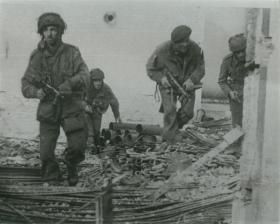 Posed shot of four paratroopers amid debris in Oosterbeek.