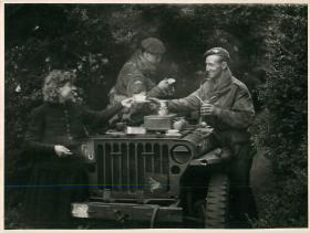 Two correspondents from the   1st Airborne Film Unit drink tea in a jeep.