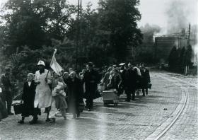 Dutch civilians are evacuated from St. Elizabeth's Hospital by a medic waving a white flag. 