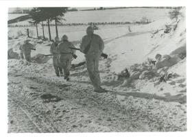Covered by bren gunner and rifleman, recce patrol move towards new position. Jan 1945.
