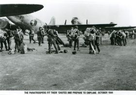 Paratroopers fit their 'chutes and prepare to emplane.