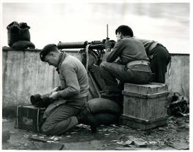 Paratroopers fire Vickers machine guns from roof of KKE building in Athens.
