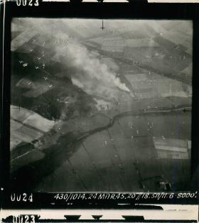Aerial photo showing aircraft dropping parachutes carrying containers before men drop.