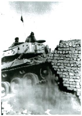 A Centurian tank demolishing houses in Gaynaeim, following trouble from snipers. Canal Zone, Egypt.