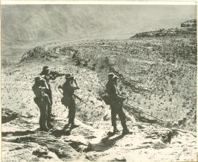 Four members of 3 PARA on patrol in a barren landscape.