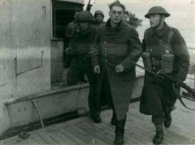 A German prisoner captured at Bruneval disembarks a landing craft.