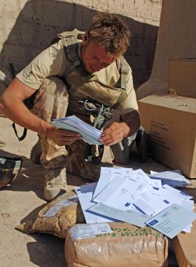 Paratrooper looking through bag of mail