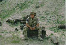 Mark Magreehan sits among spent shells, Basrah, Iraq, 2003