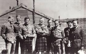 Casual group portrait of Lt Col Alistair Pearson with officers of the 8th (Midlands) Battalion, Tilshead Camp, 1944
