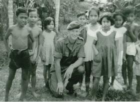 L/Cpl Denis Topping with local children in Sibu, Borneo
