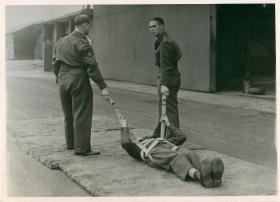 A recruit lies in a harness ready to be pulled in drag training.