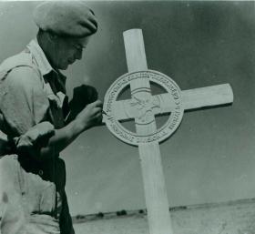 Soldier attends to the field grave of Corporal Page. 
