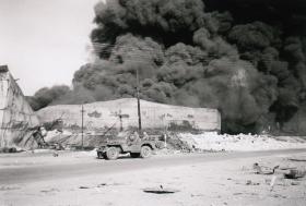 Members of 6th Airborne Divisional Signal Regt survey Oil Depot fire north of Haifa, 1947.