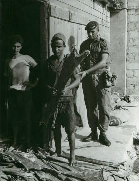 Paratrooper standing behind two locals, Aden, 1960s