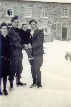 Sgmn Stevens with a Belgian family, circa January 1945.