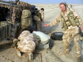 Pte Steve Lewis, 2 PARA, 'helps' with a tyre change, Iraq, 2005.