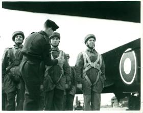 RAF jump instructor makes final checks of parachute harnesses prior to emplaning.