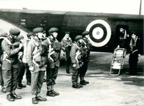 Early shot of men emplaning prior to parachute descent. 