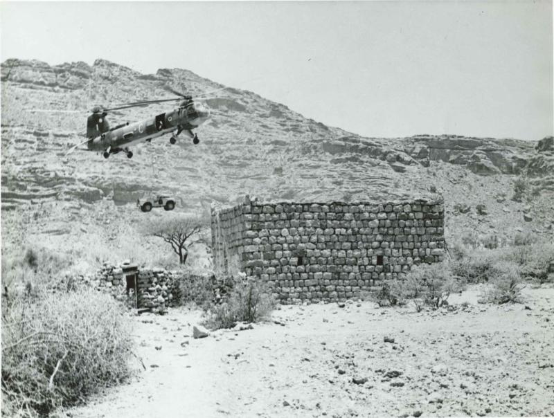 RAF Belvedere Helicopter winches a land rover into an accessible wadi in Radfan.