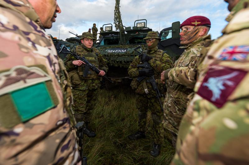 British Airborne soldiers stand with Estonian Defence League men with an armoured vehicle during Op. Tractable