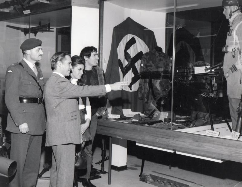 B&W photo of Richard Todd pointing at a German exhibit in the Airborne Forces Museum