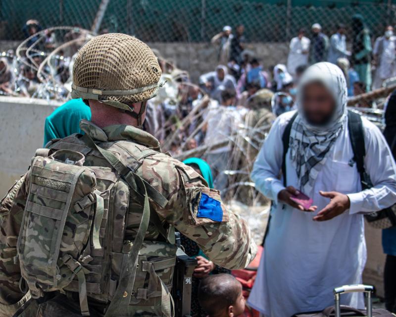 A colour photo of a member of 2 PARA talking with an Afghan, Kabul airport, August 2021
