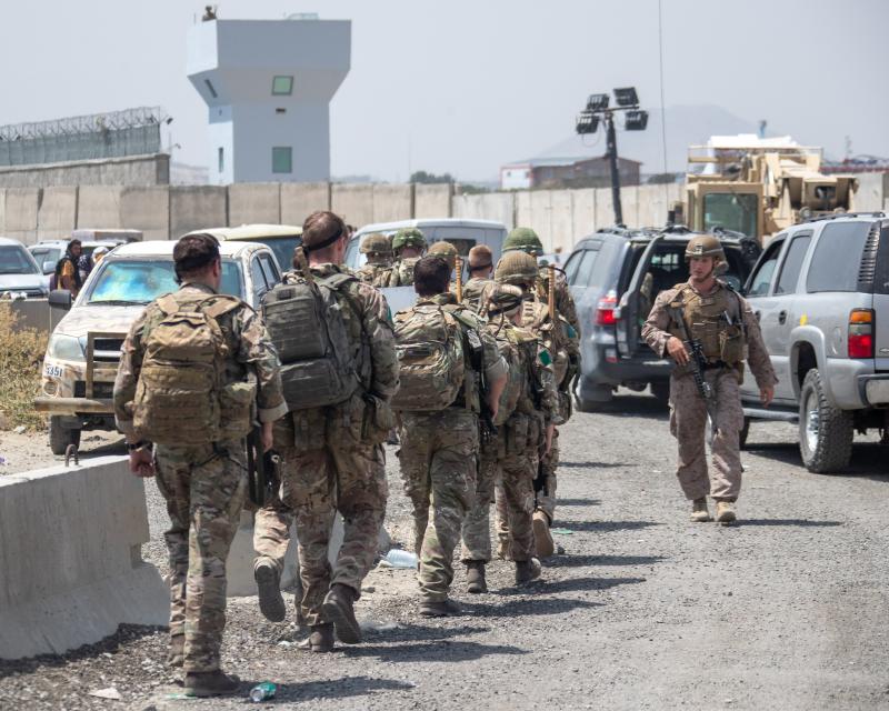 Colour photo of several Members of 3 PARA walking away from the camera, Kabul airport, August 2021