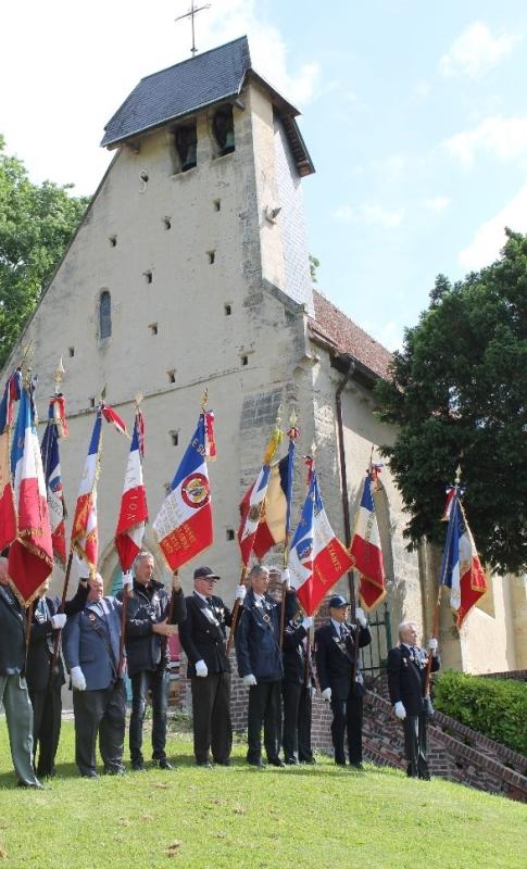 Colour photo showing standards and men at the commemorations at the church at Grangues for the murdered British servicemen.
