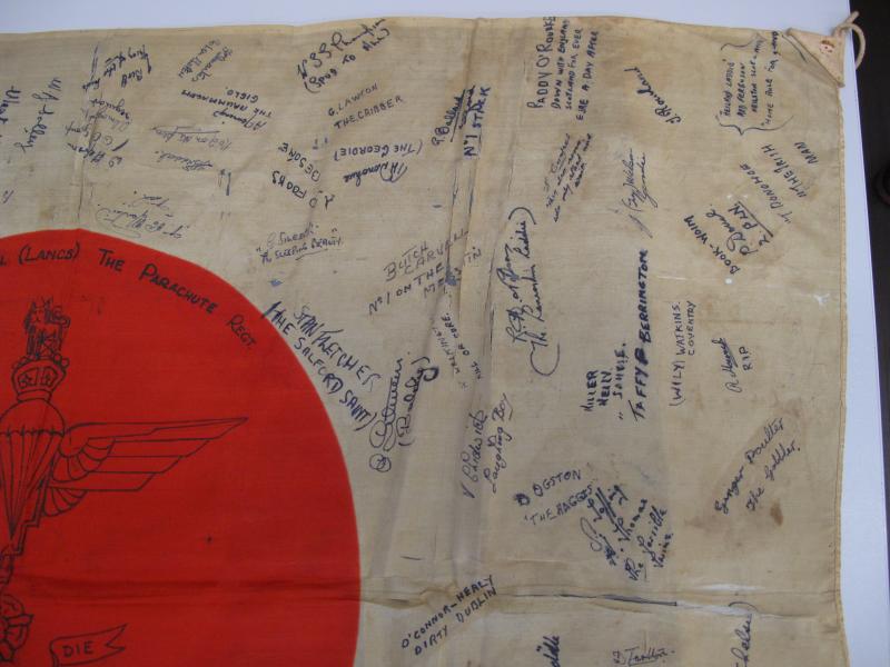 Close up top down view of a trophy Japanese flag signed by men of the 13th Lancashire Parachute Battalion