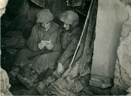 Privates Hadden and Williams rest on the floor with a book.