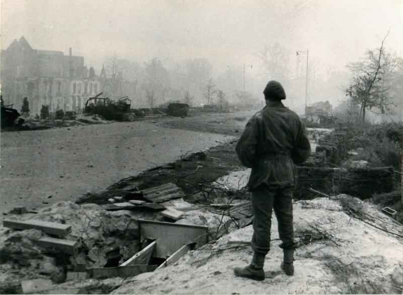 Paratrooper looks at the still destroyed Arnhem over 6 months after the battle.