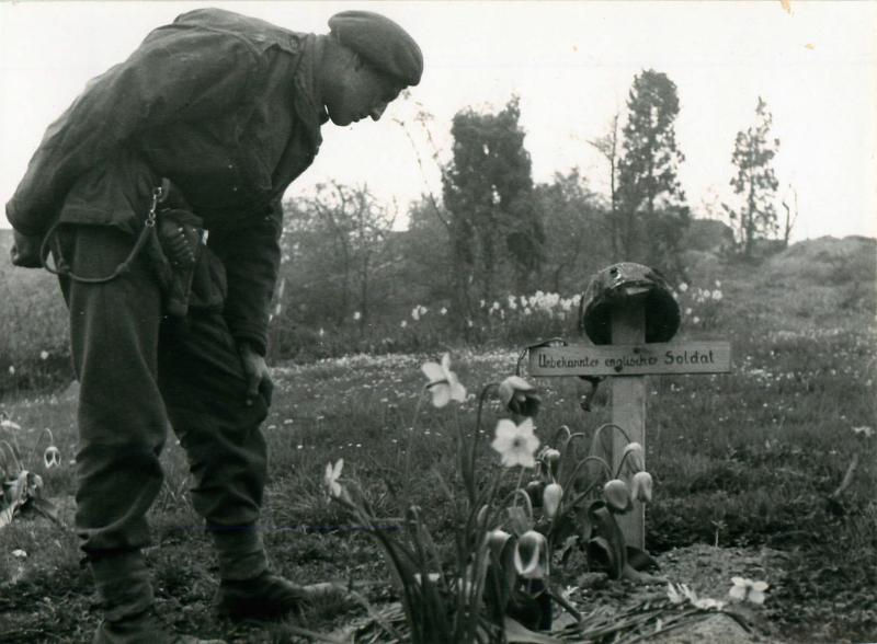 An airborne soldier looks at the grave of an unknown soldier in Arnhem, April 15th 1945.