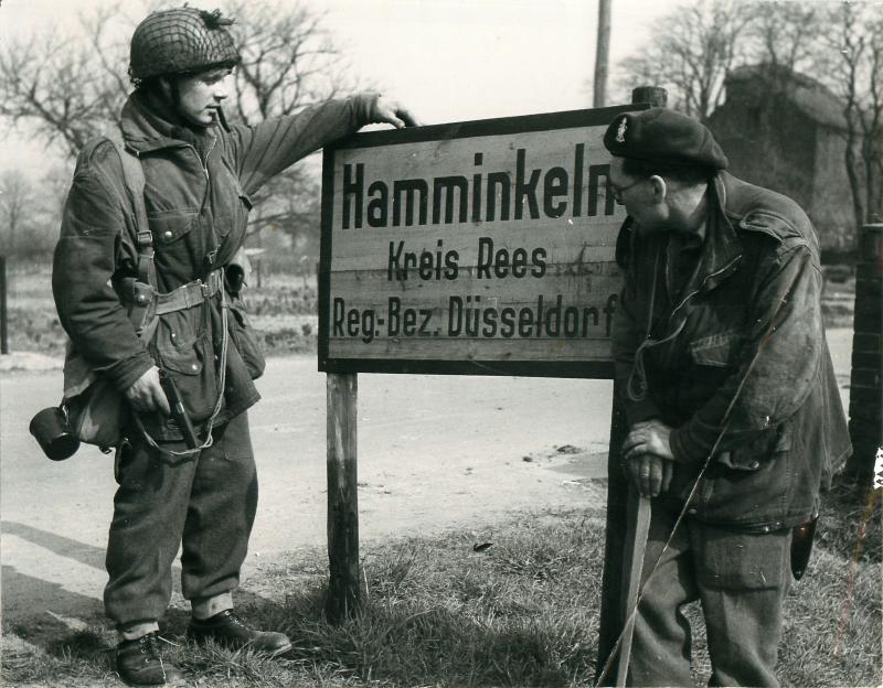 Two British airborne men by the sign for Hamminkeln the day the took the town.