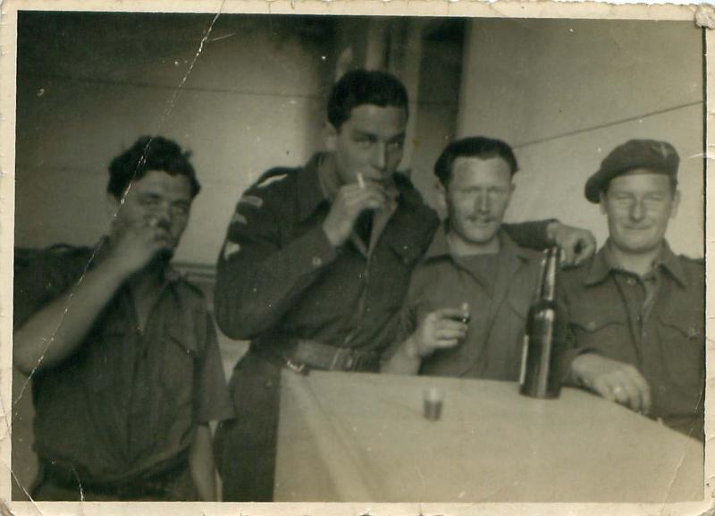 Four airborne soldiers enjoy a drink in the platoon canteen. Palestine 1946.