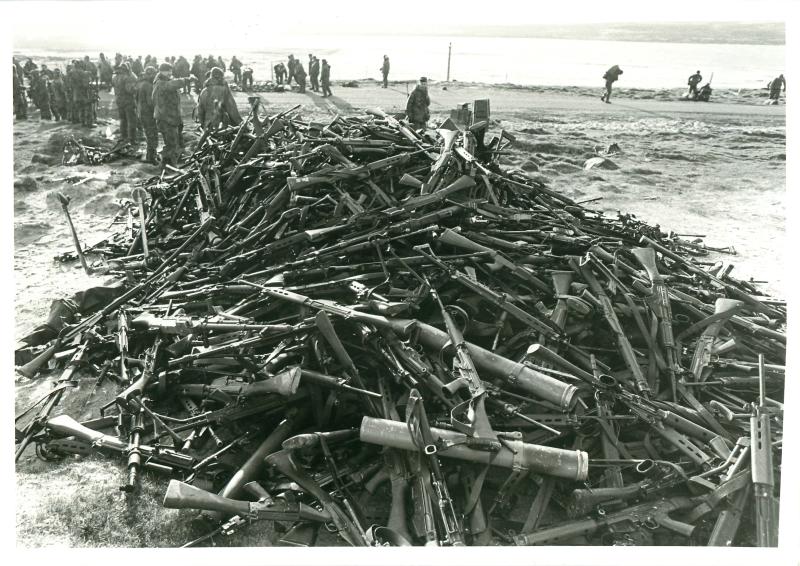 Pile of captured Argentinian weapons outside settlement of Goose Green.